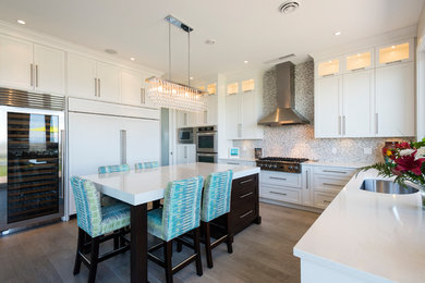 Large classic u-shaped open plan kitchen in Vancouver with a submerged sink, shaker cabinets, white cabinets, engineered stone countertops, integrated appliances and an island.