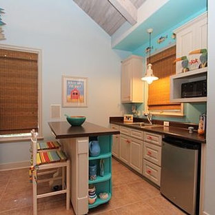 Design ideas for a small beach style single-wall eat-in kitchen in Dallas with a drop-in sink, raised-panel cabinets, white cabinets, laminate benchtops, brown splashback, stainless steel appliances, porcelain floors and with island.