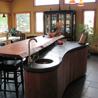 Design ideas for an expansive beach style u-shaped open plan kitchen in Seattle with an undermount sink, flat-panel cabinets, medium wood cabinets, concrete benchtops, grey splashback, ceramic splashback, stainless steel appliances, ceramic floors and with island.