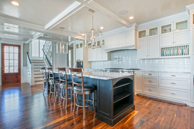 Eat-in kitchen - large transitional u-shaped dark wood floor eat-in kitchen idea in Boston with a farmhouse sink, raised-panel cabinets, white cabinets, soapstone countertops, white backsplash, subway tile backsplash, stainless steel appliances and an island
