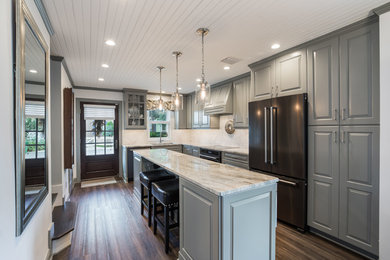 Inspiration for a small craftsman l-shaped vinyl floor and brown floor eat-in kitchen remodel in Jacksonville with an undermount sink, raised-panel cabinets, gray cabinets, granite countertops, white backsplash, marble backsplash, black appliances, an island and multicolored countertops