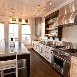 Design ideas for a beach style kitchen in Raleigh with stainless steel appliances, soapstone benchtops, a farmhouse sink, louvered cabinets and grey cabinets.