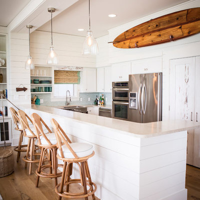 Open concept kitchen - coastal l-shaped open concept kitchen idea in Other with stainless steel appliances and white cabinets