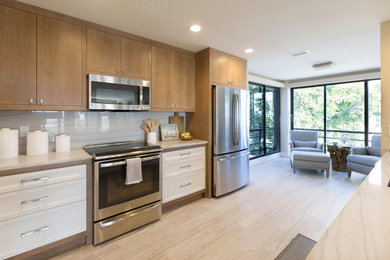 Inspiration for a mid-sized transitional galley porcelain tile and beige floor open concept kitchen remodel in Orlando with a drop-in sink, beaded inset cabinets, white cabinets, quartzite countertops, gray backsplash, stone slab backsplash, stainless steel appliances and an island