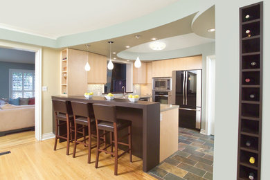 Inspiration for a mid-sized transitional u-shaped slate floor and green floor eat-in kitchen remodel in Toronto with an undermount sink, flat-panel cabinets, light wood cabinets, granite countertops, green backsplash, mosaic tile backsplash, stainless steel appliances, a peninsula and green countertops
