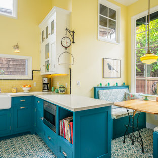 Inspiration for a small country u-shaped eat-in kitchen in Los Angeles with a farmhouse sink, beaded inset cabinets, blue cabinets, quartz benchtops, yellow splashback, subway tile splashback, white appliances, cement tiles, blue floor and white benchtop.