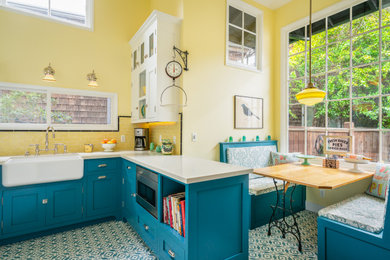 Small farmhouse u-shaped cement tile floor and blue floor eat-in kitchen photo in Los Angeles with a farmhouse sink, beaded inset cabinets, blue cabinets, quartz countertops, yellow backsplash, subway tile backsplash, white appliances and white countertops