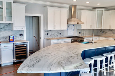 Large beach style kitchen in Baltimore with white cabinets, quartz worktops, stone slab splashback and an island.