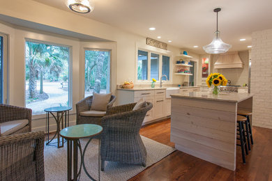 Open concept kitchen - coastal u-shaped medium tone wood floor open concept kitchen idea in Charleston with a farmhouse sink, shaker cabinets, white cabinets, granite countertops, stainless steel appliances and an island