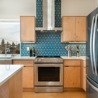 Esempio di una cucina moderna di medie dimensioni con lavello stile country, ante lisce, ante in legno chiaro, top in quarzo composito, paraspruzzi blu, paraspruzzi con piastrelle di cemento, elettrodomestici in acciaio inossidabile, pavimento in bambù, pavimento marrone e top bianco