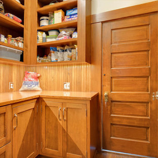 This is an example of a mid-sized l-shaped kitchen pantry in Seattle with a farmhouse sink, recessed-panel cabinets, medium wood cabinets, wood benchtops, orange splashback, timber splashback, medium hardwood floors, no island, orange floor and orange benchtop.