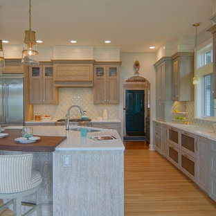 Idee per una cucina a L costiera con lavello sottopiano, ante in stile shaker, ante turchesi, top in quarzite, elettrodomestici in acciaio inossidabile, pavimento in legno massello medio, isola, pavimento marrone e top bianco