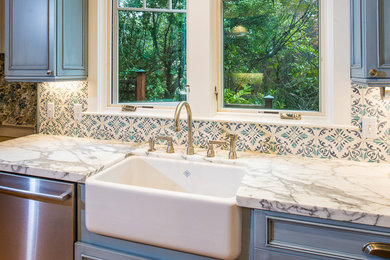 Example of a mid-sized farmhouse kitchen design in San Francisco with a farmhouse sink, recessed-panel cabinets, blue cabinets, marble countertops, blue backsplash, cement tile backsplash and stainless steel appliances