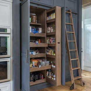 Ejemplo de cocina clásica renovada, grande, con electrodomésticos de acero inoxidable, suelo de madera en tonos medios y armarios estilo shaker