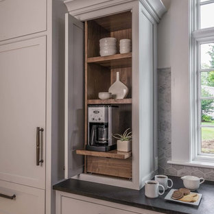 Immagine di una grande cucina tradizionale con lavello sottopiano, ante bianche, top in saponaria, paraspruzzi grigio, paraspruzzi con piastrelle in ceramica, elettrodomestici in acciaio inossidabile, pavimento in legno massello medio e ante a filo