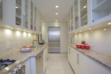Medium sized traditional galley kitchen pantry in New York with a submerged sink, glass-front cabinets, white cabinets, granite worktops, white splashback, metro tiled splashback, stainless steel appliances, ceramic flooring and no island.