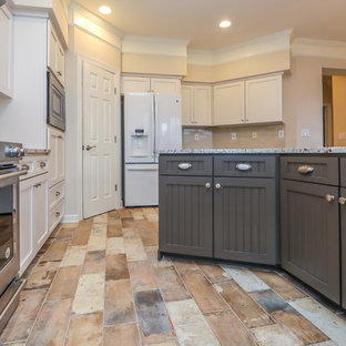 Medium sized farmhouse l-shaped kitchen/diner with a belfast sink, recessed-panel cabinets, white cabinets, granite worktops, beige splashback, ceramic splashback, stainless steel appliances, porcelain flooring, an island, multi-coloured floors and multicoloured worktops.