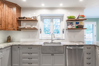 Example of a large transitional light wood floor and brown floor eat-in kitchen design in Kansas City with a farmhouse sink, recessed-panel cabinets, granite countertops, white backsplash, subway tile backsplash, stainless steel appliances and dark wood cabinets