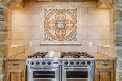Ejemplo de cocina grande con encimera de granito, salpicadero beige, electrodomésticos de acero inoxidable, suelo de madera oscura y suelo marrón