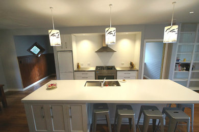 Exempel på ett stort modernt kök och matrum, med vita skåp och en köksö