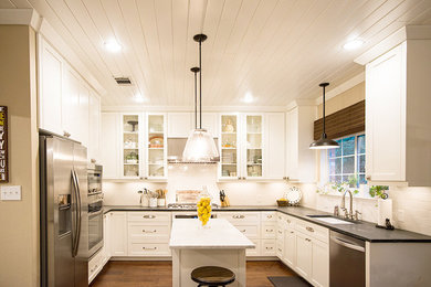 Eat-in kitchen - transitional eat-in kitchen idea in Austin with an undermount sink, shaker cabinets, white backsplash, stainless steel appliances and an island