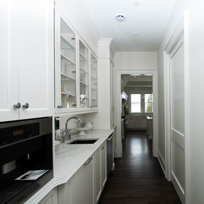 Huge elegant l-shaped dark wood floor and brown floor open concept kitchen photo in Other with an undermount sink, recessed-panel cabinets, white cabinets, quartz countertops, gray backsplash, marble backsplash, stainless steel appliances and an island