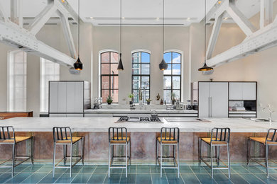 Idee per un'ampia cucina industriale con ante lisce, ante bianche, top in marmo, elettrodomestici da incasso, pavimento verde e top grigio