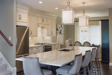 Example of a mid-sized classic single-wall dark wood floor open concept kitchen design in Other with an undermount sink, recessed-panel cabinets, white cabinets, marble countertops, white backsplash, porcelain backsplash, stainless steel appliances and an island