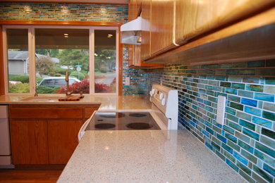 Mid-sized beach style l-shaped enclosed kitchen photo in Portland with an undermount sink, flat-panel cabinets, light wood cabinets, granite countertops, multicolored backsplash, glass tile backsplash, white appliances and no island