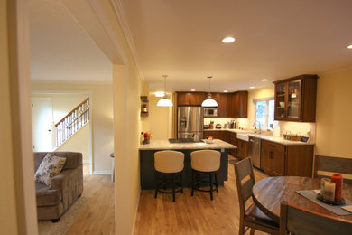 Example of a mid-sized arts and crafts l-shaped dark wood floor and brown floor open concept kitchen design in Portland with a farmhouse sink, shaker cabinets, dark wood cabinets, granite countertops, beige backsplash, porcelain backsplash, stainless steel appliances, a peninsula and gray countertops