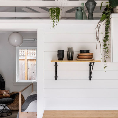Example of a small beach style single-wall concrete floor and gray floor eat-in kitchen design in Portland with a single-bowl sink, wood countertops, white backsplash, wood backsplash and stainless steel appliances
