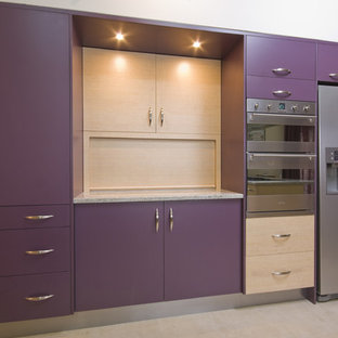 This is an example of a mid-sized modern u-shaped open plan kitchen in Sydney with flat-panel cabinets, purple cabinets, granite benchtops, stainless steel appliances, ceramic floors, no island and beige floor.