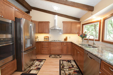 Transitional u-shaped eat-in kitchen photo in Omaha with a double-bowl sink, shaker cabinets, subway tile backsplash, stainless steel appliances and multicolored countertops