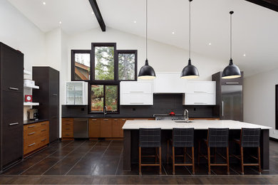 Inspiration for a mid-sized modern l-shaped porcelain tile eat-in kitchen remodel in Calgary with a single-bowl sink, flat-panel cabinets, black cabinets, granite countertops, gray backsplash, stainless steel appliances, an island and porcelain backsplash