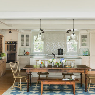 Inspiration for a mid-sized timeless l-shaped light wood floor and beige floor eat-in kitchen remodel in Boston with an undermount sink, white cabinets, granite countertops, mosaic tile backsplash, stainless steel appliances, an island and metallic backsplash