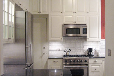 Example of a mid-sized classic l-shaped porcelain tile eat-in kitchen design in Other with an undermount sink, raised-panel cabinets, white cabinets, granite countertops, white backsplash, subway tile backsplash, stainless steel appliances and a peninsula