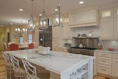 Large elegant l-shaped light wood floor eat-in kitchen photo in Charleston with a farmhouse sink, white cabinets, granite countertops, gray backsplash, mosaic tile backsplash, stainless steel appliances, an island and recessed-panel cabinets