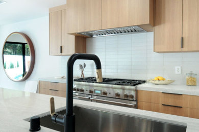 Große Moderne Küche mit flächenbündigen Schrankfronten, Quarzwerkstein-Arbeitsplatte, Rückwand aus Keramikfliesen und braunem Holzboden in Los Angeles