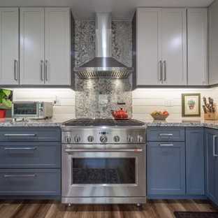 Design ideas for a large country l-shaped kitchen pantry in Miami with a farmhouse sink, shaker cabinets, blue cabinets, granite benchtops, beige splashback, shiplap splashback, stainless steel appliances, vinyl floors, a peninsula, brown floor and multi-coloured benchtop.