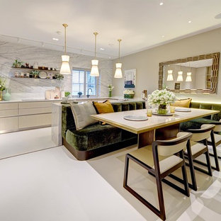 Large contemporary u-shaped kitchen/diner in London with flat-panel cabinets, light wood cabinets, marble worktops, marble splashback, porcelain flooring, white floors, black appliances and a breakfast bar.