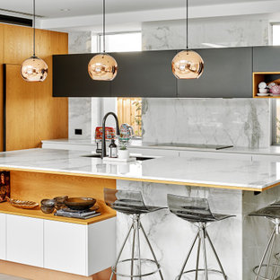Design ideas for a large contemporary l-shaped kitchen in Sydney with an undermount sink, flat-panel cabinets, white cabinets, solid surface benchtops, grey splashback, porcelain splashback, panelled appliances, porcelain floors, with island, grey floor and white benchtop.