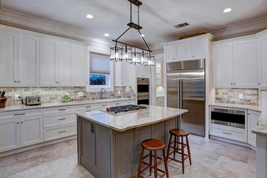 Mid-sized arts and crafts l-shaped porcelain tile and gray floor eat-in kitchen photo in Houston with an undermount sink, shaker cabinets, white cabinets, quartzite countertops, gray backsplash, travertine backsplash, stainless steel appliances, an island and beige countertops