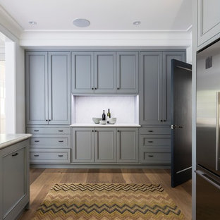 Foto di una grande cucina classica con lavello sottopiano, ante con riquadro incassato, ante grigie, top in marmo, paraspruzzi grigio, paraspruzzi in lastra di pietra, elettrodomestici in acciaio inossidabile, parquet chiaro e penisola