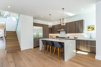 Example of a mid-sized trendy l-shaped light wood floor and beige floor eat-in kitchen design in San Francisco with an undermount sink, flat-panel cabinets, medium tone wood cabinets, quartz countertops, white backsplash, quartz backsplash, stainless steel appliances, an island and white countertops