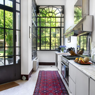 Immagine di una cucina lineare minimal con ante lisce, ante grigie, elettrodomestici in acciaio inossidabile, top bianco, paraspruzzi bianco e pavimento bianco