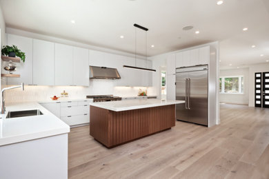 Example of a minimalist light wood floor and beige floor kitchen design in San Francisco with a single-bowl sink, quartz countertops, white backsplash, porcelain backsplash, stainless steel appliances and white countertops