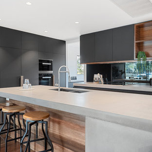 This is an example of a large industrial galley eat-in kitchen in Brisbane with mirror splashback, medium hardwood floors, with island, grey benchtop, a double-bowl sink, flat-panel cabinets, grey cabinets and brown floor.