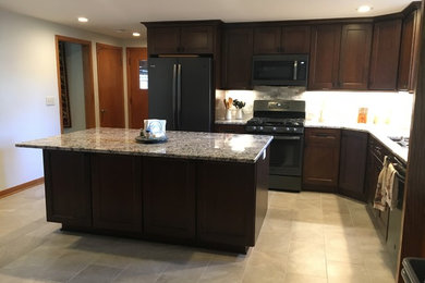 Inspiration for a l-shaped eat-in kitchen remodel in Milwaukee with an undermount sink, shaker cabinets, brown cabinets, granite countertops, beige backsplash, an island and beige countertops