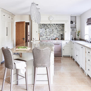 This is an example of a classic enclosed kitchen in Wiltshire with a submerged sink, white cabinets, multi-coloured splashback, coloured appliances, an island, beige floors and beige worktops.