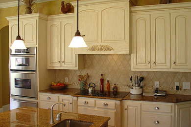 Example of a mid-sized classic kitchen design in Miami with an undermount sink, raised-panel cabinets, white cabinets, beige backsplash, stainless steel appliances, an island and ceramic backsplash
